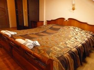 1 cama grande con marco de madera y toallas. en Karczma Góralska, en Wisznice