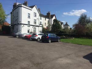 um grupo de carros estacionados em frente a uma casa branca em Crescent Hotel em Reading