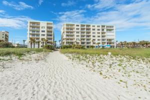 a path through the sand at the beach with two condos at Sandcastles in Cocoa Beach