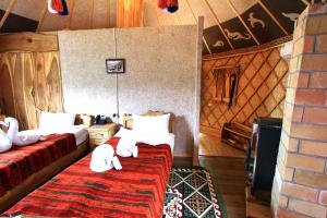 een slaapkamer met 2 bedden in een kamer met een muur bij Supara Chunkurchak in Alamedin