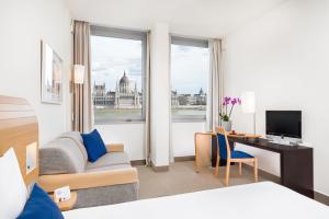 a hotel room with two beds and a television at Novotel Budapest Danube in Budapest