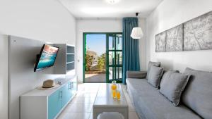 a living room with a couch and a tv at Apartamentos Los Veleros in Puerto Rico de Gran Canaria