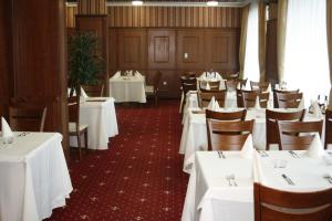 a dining room with white tables and chairs at Hotel Elegance in Asenovgrad