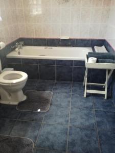 a bathroom with a tub and a toilet and a sink at A Wave from it all in Port Shepstone