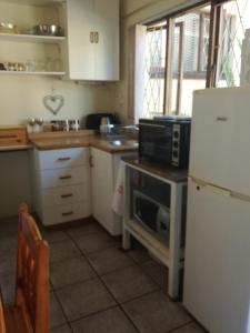 a kitchen with a white refrigerator and a microwave at A Wave from it all in Port Shepstone