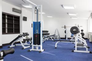 a gym with several treadmills and weights at President Hotel in Ufa