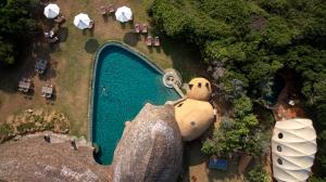 a statue of a penguin sitting on top of a lush green field at Wild Coast Tented Lodge All Inclusive in Yala