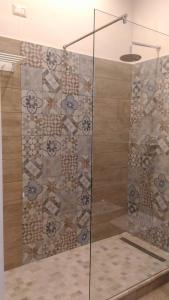 ジャルディーニ・ナクソスにあるB&B Villa Raineriのバスルーム(ガラスドア付きのシャワー付)