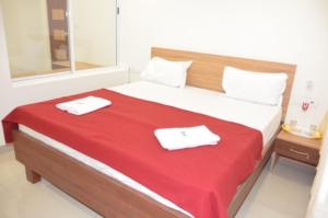 1 dormitorio con 1 cama grande y 2 toallas. en Raya's Inn, en Kumbakonam