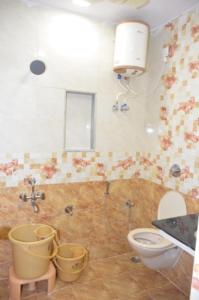 y baño con aseo y cubos. en Raya's Inn, en Kumbakonam