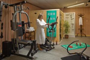 a woman standing in a gym with a treadmill at Grand Hotel de Valloire et du Galibier in Valloire
