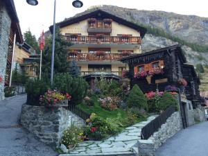 un edificio con flores delante en Hotel Romantica en Zermatt