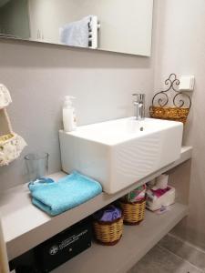 ein Badezimmer mit einem weißen Waschbecken und einigen Körben in der Unterkunft Wonderful Apartment in central Athens in Athen
