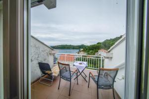 d'un balcon avec des chaises et une table offrant une vue sur l'eau. dans l'établissement Guest House Matana Pomena, à Pomena