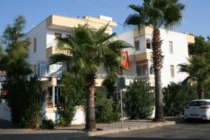 un edificio blanco con palmeras delante en Ekin Hotel, en Marmaris