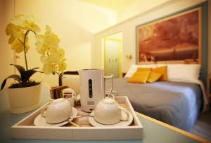 a tray with two tea sets on a table in a bedroom at La Bella Napoli B&B in Naples