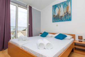 a bedroom with a large bed with a window at Apartments in city center Ventus in Novalja