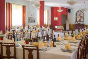 a room with long tables and chairs with wine bottles at Ristorante Buasca in Cuorgnè