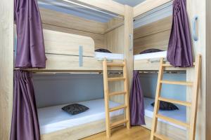 a bunk bed room with two bunk beds and a ladder at Apartments in city center Ventus in Novalja