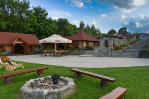 a park with benches and a fire pit in the grass at Stanica Hucuł in Sułkowice