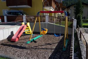 a playground with colorful playground equipment in a yard at Appartamenti Lercher Anna in San Candido