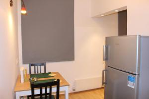 uma cozinha com uma mesa e um frigorífico de aço inoxidável em Karmeliter Home em Viena