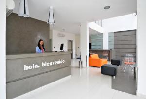 a woman standing behind a counter in a lobby at Hotel LP Santa Cruz Centro in Santa Cruz de la Sierra