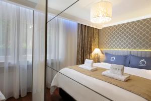 ein Schlafzimmer mit einem großen Bett und einem Kronleuchter in der Unterkunft The Queen Luxury Apartments - Villa Vinicia in Luxemburg (Stadt)