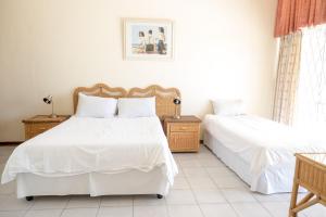 two beds in a room with white walls and white floors at Seabrook 001 - Margate RSA in Margate