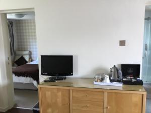 um quarto com uma televisão numa cómoda com uma cama em Ingleneuk Bed and Breakfast em Edimburgo