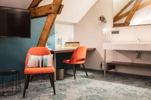 a bathroom with orange chairs and a sink at Hotel de Koppelpaarden in Lichtenvoorde