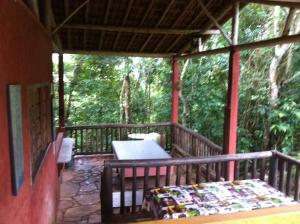 a porch of a house with a bed on it at Pousada Tabuleiro Eco in Conceição do Mato Dentro