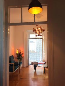 a living room with a table and a chandelier at Design Apartment with Rooftop Terrace and 180-degree River&City Views in Lisbon