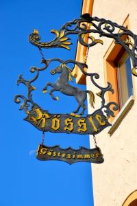 un cartello sul lato di un edificio con un cavallo di Hotel-Gasthof Rössle a Ulma