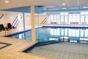 a large swimming pool in a building at Zeebries in De Kaap 4 p in Hollum