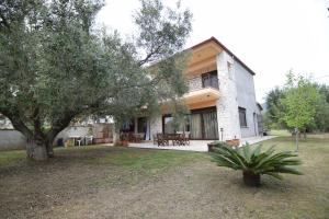 a house with a tree in front of it at Holiday Villa Vee in Nea Skioni