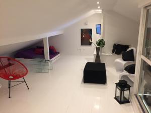 een woonkamer met een rode stoel en een bank bij Design Maisonette - Rooftop Terrace in Lissabon