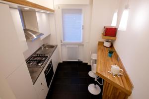uma pequena cozinha com um lavatório e uma bancada em Nuovissimo e luminoso appartamento centro Pordenone em Pordenone