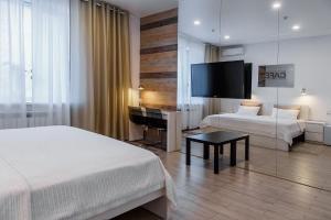 una camera d'albergo con 2 letti e una scrivania di Hotel Prizma a Penza