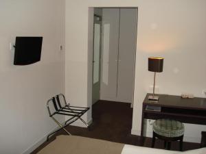 a room with a desk and a chair and a lamp at Hôtel Ronsard in Tours