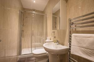 a bathroom with a toilet and a sink and a shower at Waterfront Apartments in Douglas