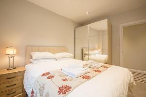 a bedroom with a large bed with towels on it at Waterfront Apartments in Douglas