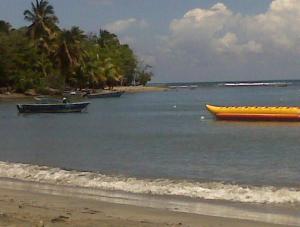 a boat in the water next to a beach at Villa Ana in Pajarito