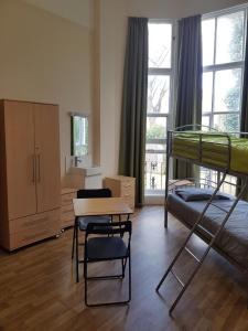 a bedroom with a bunk bed and a desk and chairs at Belsize House (Belsize Park) in London