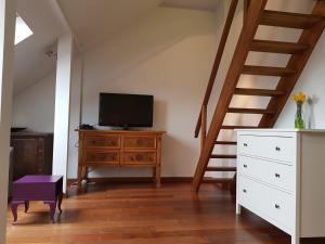 a living room with a television on a dresser and a staircase at Apartament Nowy Świat in Warsaw