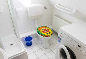 a small bathroom with a toilet with a colorful seat at Ferienwohnung Lampe in Neustadt in Holstein