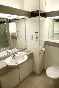 a bathroom with a sink, toilet and mirror at Eastwood Hall in Eastwood