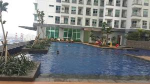 a large swimming pool in front of a building at Robert's Condominium in Jakarta