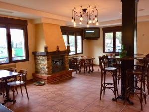un restaurante con chimenea, mesas y sillas en Hotel Rural Nova Ruta, en Trabadelo