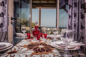 a table with glasses and plates and a vase on it at Villa Dream in Matala